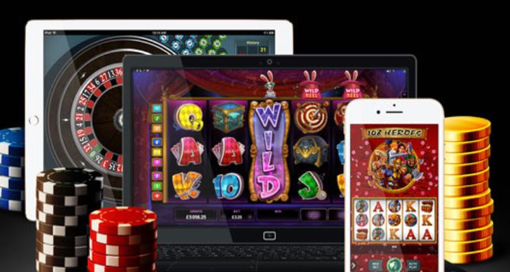En datorskärm, en surfplatta och en mobiltelefon med casinospel omgivna av spelmarker.